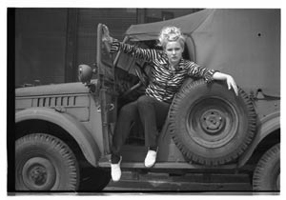 Blondine sitzt auf Militärauto